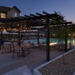 Apartment complex outdoor area with pergola, lounge area, and pool - Elements at Prairie Center