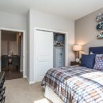 Bedroom with closet and door to living space in an apartment - Elements at Prairie Center