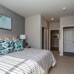 Large bedroom with closet and door to living space in an apartment home- Elements at Prairie Center