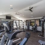 Apartment fitness center with treadmills and weights - Elements at Prairie Center