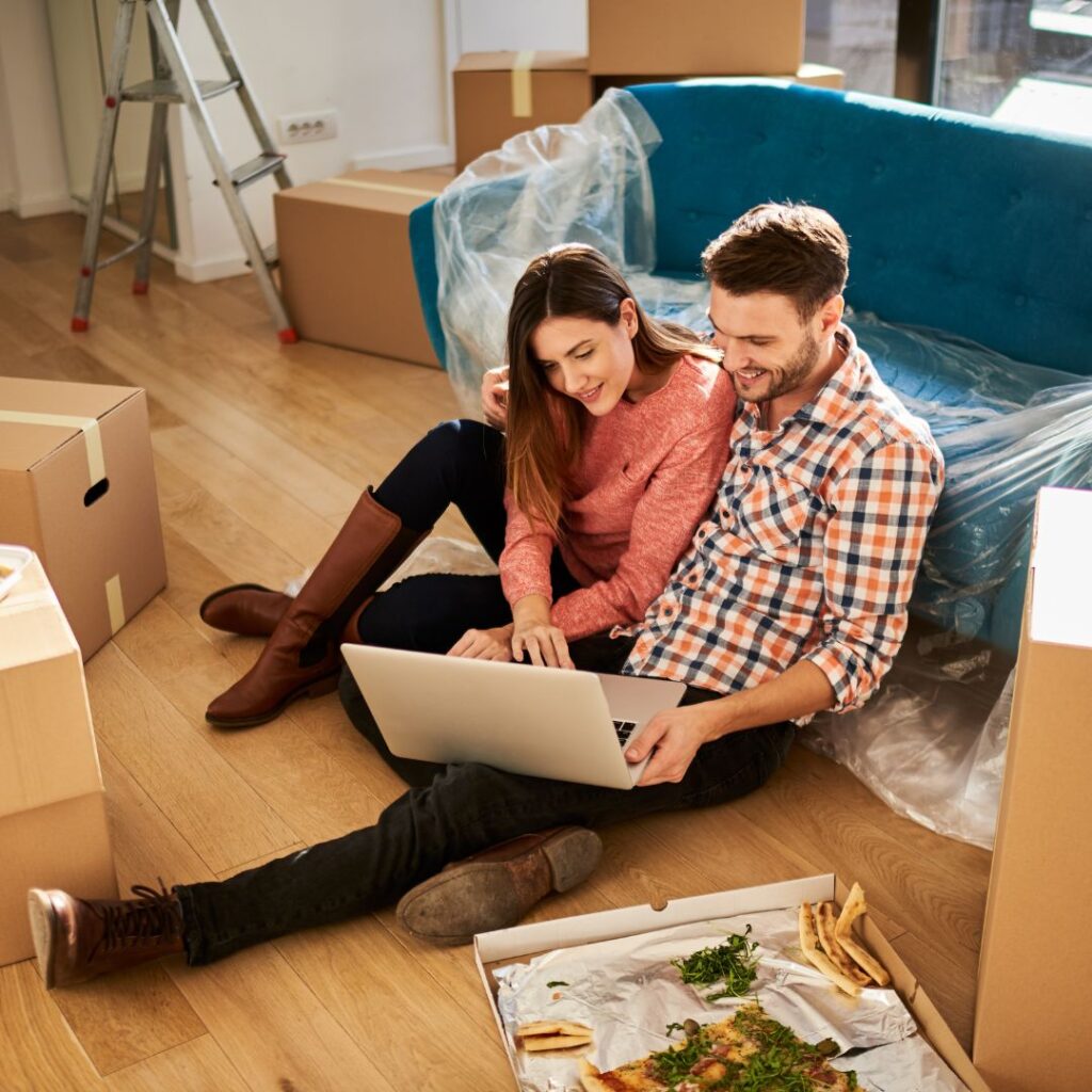 young couple on laptop in new apartment