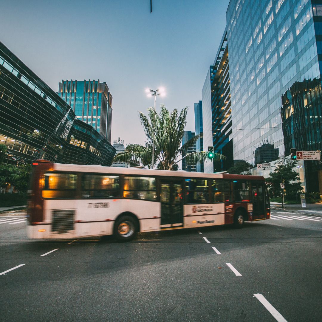 Blurred bus passing through city with glass buildings