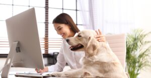 woman working from home while petting her dog