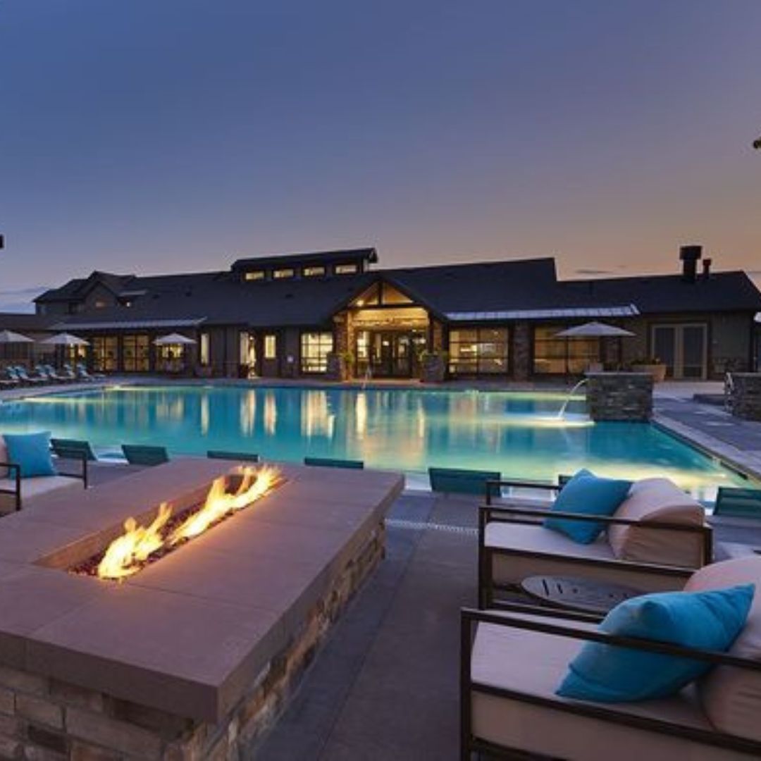 Outdoor firepit near large pool at dusk