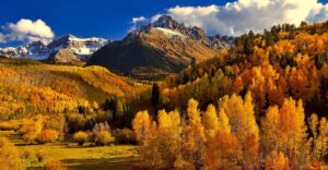 Mountain landscape with golden autumn trees and snowy peaks