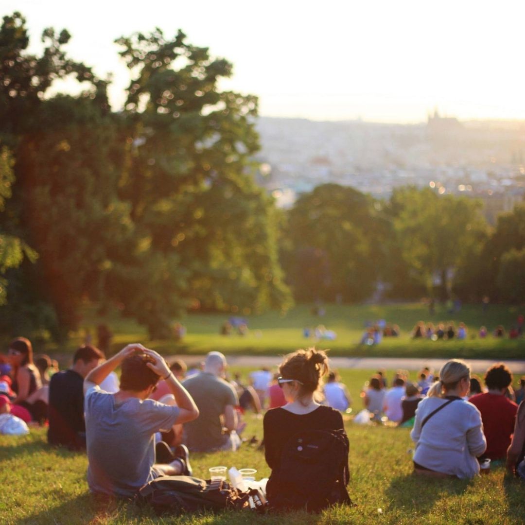 Group of young adults sitting in the grass at a park