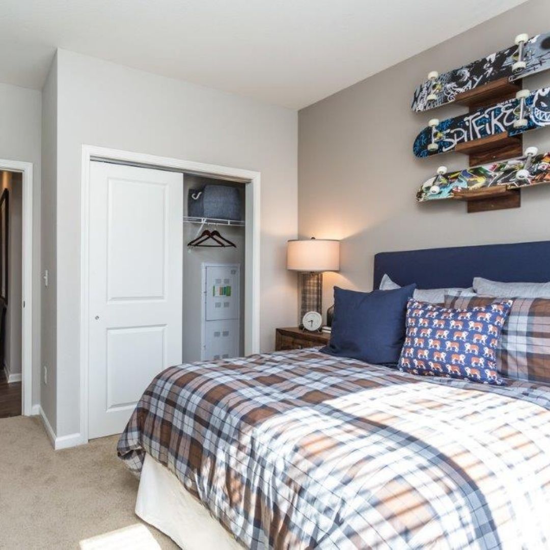 spacious bedroom with skateboards hanging on wall
